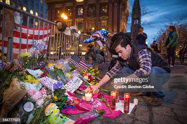 Sam Galvin of West Roxbury, added candles to a make-shift memorial was set up on the barricades blocking off Boylston Street at its intersection with...