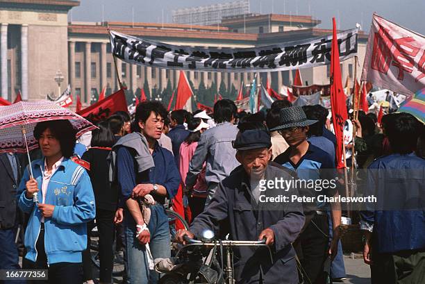 An old man with a bicycle takes a walk in Tiananmen Square to see the protestors for himself. Pro-democracy demonstrators and protestors filled the...