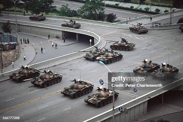 At the end of the pro-democracy protests in China, a group of Chinese Army tanks block an overpass on Chang'an Avenue leading to Tiananmen Square...