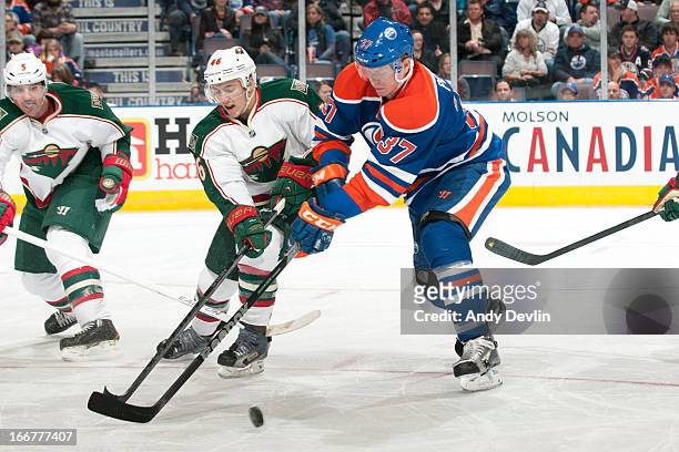 Lennart Petrell of the Edmonton Oilers battles for the puck against Jared Spurgeon of the Minnesota Wild on April 16, 2013 at Rexall Place in...