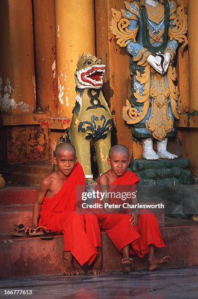 Two novice monks sit on steps in the Shwedagon Pagoda in central Rangoon..