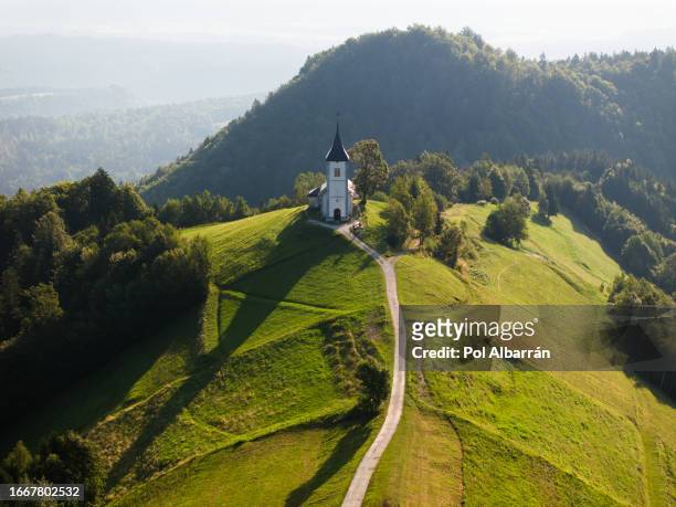aerial view of st. primoz church in jamnik, slovenia, on a sunny summer day, captivating alpine landscape - kranj 個照片及圖片檔