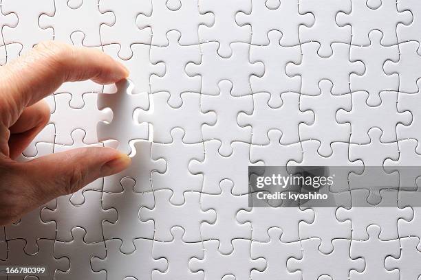 holding a blank final piece of the jigsaw - connect the dots puzzle stock pictures, royalty-free photos & images