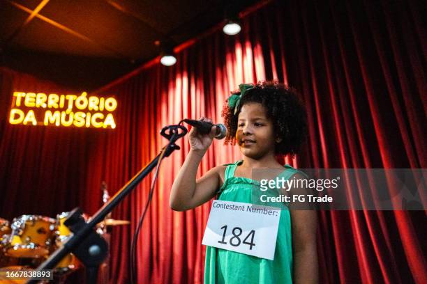 girl singing in a music contest - kid actor stock pictures, royalty-free photos & images