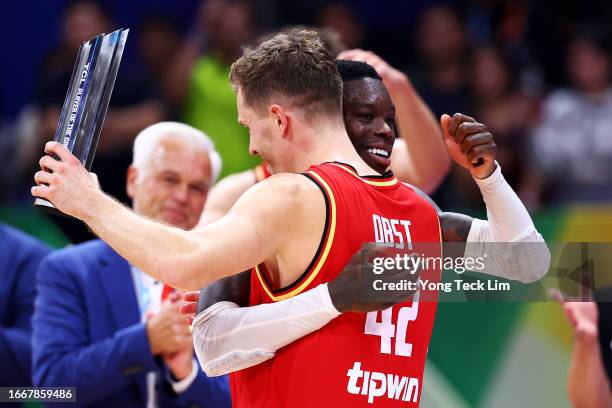 Andreas Obst of Germany is congratulated by teammate Dennis Schroder after being awarded Player of the Game honors following the FIBA Basketball...