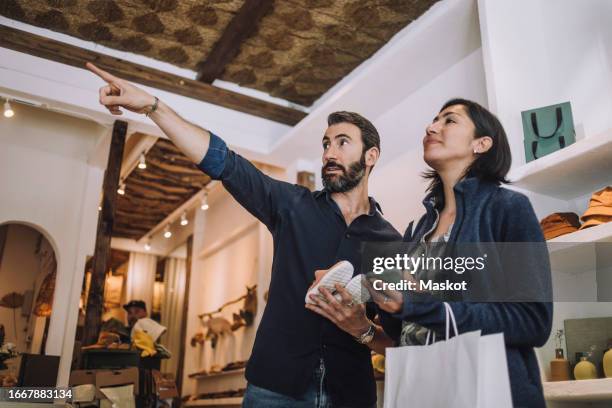 salesman pointing to female customer in clothing store - low angle view fashion stock pictures, royalty-free photos & images