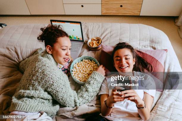 happy female friends with smart phone and laptop spending leisure time at home - teenager icon stock pictures, royalty-free photos & images