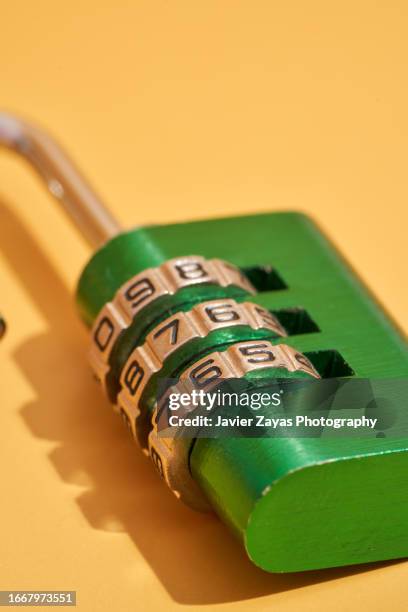 green padlock with numerical combination on yellow background - password strength stock pictures, royalty-free photos & images