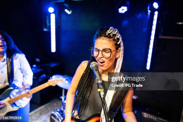 young woman singing and playing bass on a show - popmusik bildbanksfoton och bilder