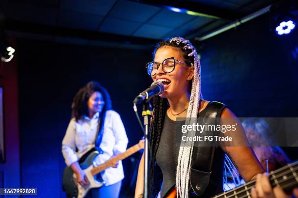 young woman singing and playing bass on a show - black woman singer stock pictures, royalty-free photos & images