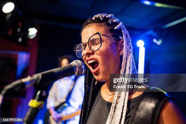 mujer joven cantando en un espectáculo - base de pie para micrófono fotografías e imágenes de stock