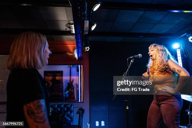 junge frau spricht während stand-up-comedy-show - stand up comedy stock-fotos und bilder