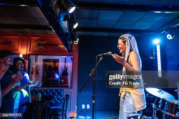 junge frau spricht während stand-up-comedy-show - stand up comedy stock-fotos und bilder
