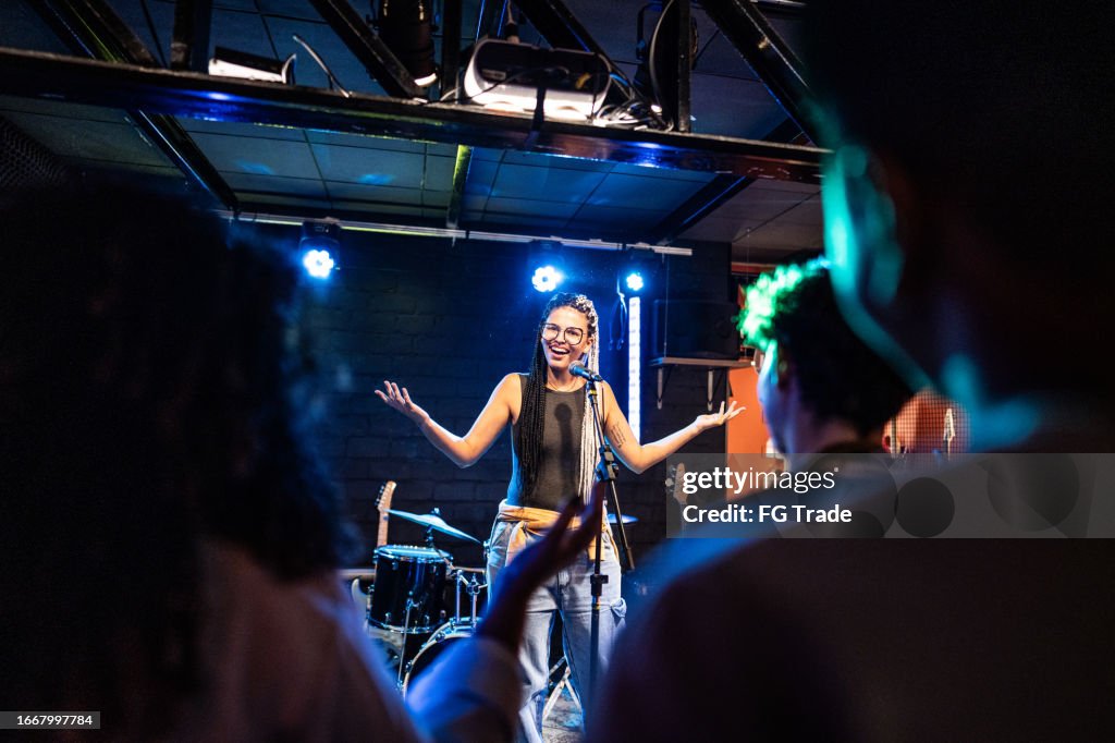 Young woman talking during stand-up comedy show