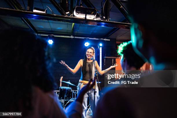 young woman talking during stand-up comedy show - comedian on stage stock pictures, royalty-free photos & images