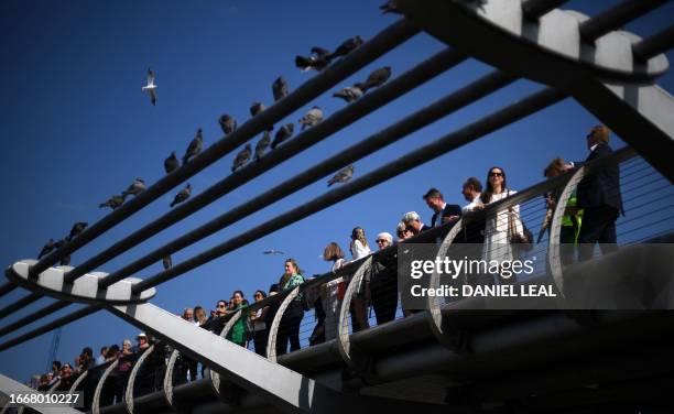 Business professionals pose for a photograph as they take part in a 'Queue for Climate & Nature' demonstration calling on UK Political Party leaders...