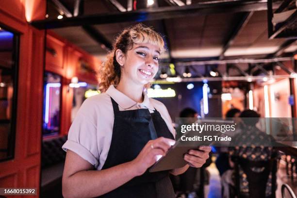 portrait of a waitress young woman using digital tablet on a restaurant - empregada de mesa imagens e fotografias de stock