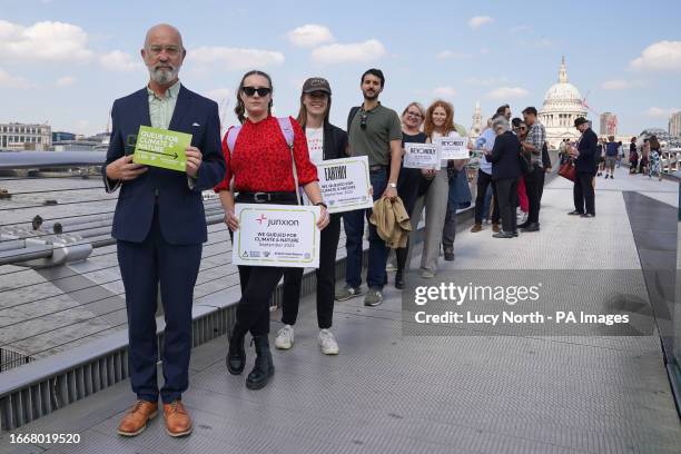Demonstrators wearing business attire on Millennium Bridge in London during a Queue for Climate & Nature demonstration. Picture date: Friday...
