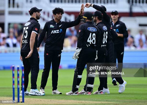 New Zealand's Rachin Ravindra celebrates with teammates after taking the wicket of England's Joe Root for 29 runs during the fourth One Day...