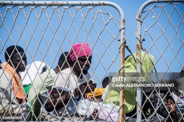 Migrants gather on the deck of Italian military ship Cassiopea, in the harbour of Italian island of Lampedusa, before being transferred to Porto...