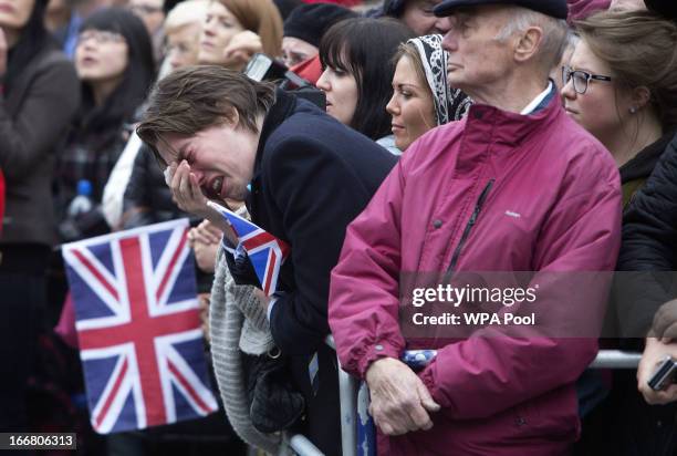 Member of the public weeps as the coffin of Baroness Thatcher is carried out of St Clement Danes church for the start of her state funeral procession...