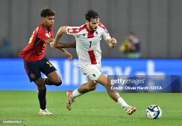 Khvicha Kvaratskhelia of Georgia battles for possession with Lamine Yamal of Spain during the UEFA EURO 2024 European qualifier match between Georgia...