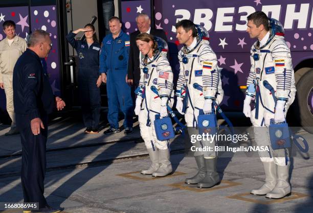 Expedition 70 crew members NASA astronaut Loral O'Hara, left, and Roscosmos cosmonauts Oleg Kononenko, center, and Nikolai Chub, right, check in with...