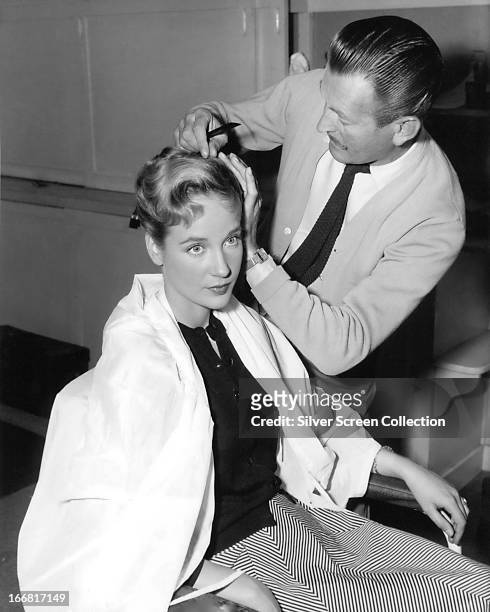 English actress Sylvia Syms having her hair styled, circa 1958.