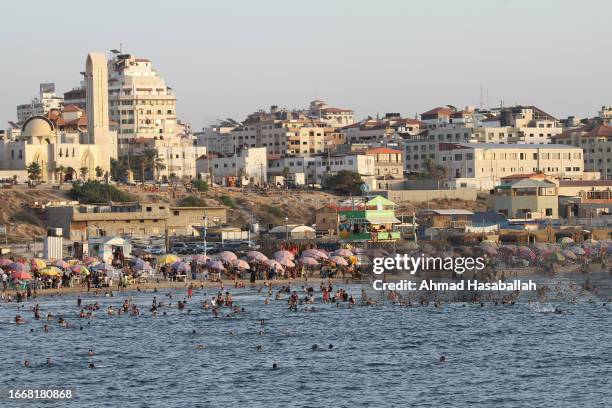 People visit the beach to get relief from high temperatures and long hours of power outages September 8, 2023 in Gaza City, Gaza.