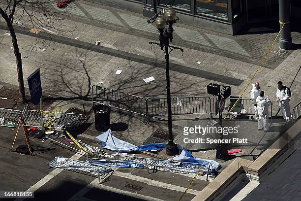 Investigators stand at the scene of twin bombings at the Boston Marathon on April 17, 2013 in Boston, Massachusetts. The explosions, which occurred...