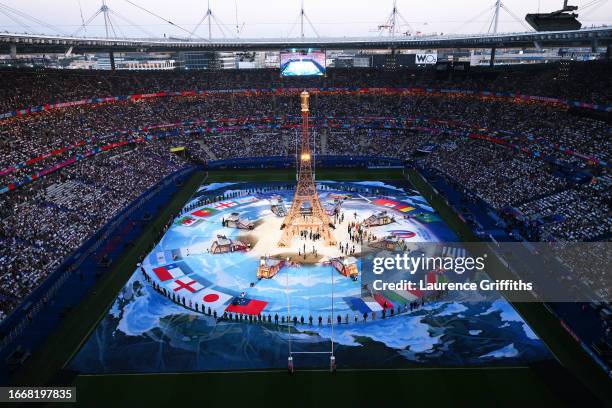 General view of the inside of the stadium, as a replica of the Eiffel Tower is seen, during the Opening Ceremony as flags of the competing nations...