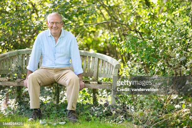 senior man sitting on an old bench in his garden - buff stock pictures, royalty-free photos & images