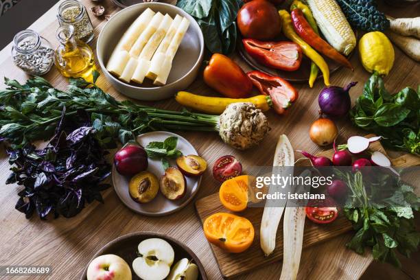 fresh homegrown vegetables and fruits on kitchen table, preparing food - colorful vegetables summer stock-fotos und bilder