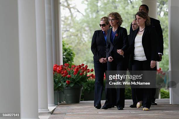 Former U.S. Rep. Gabrielle Giffords escorts family members of Newtown, CT shooting victims before U.S. President Barack Obama makes a statement on...