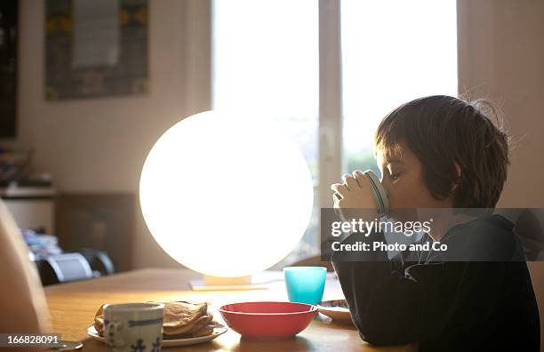 kid having breakfast with light therapy lamp - luminothérapie photos et images de collection