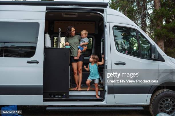 mother and children stand in van while camping - camper van stock pictures, royalty-free photos & images