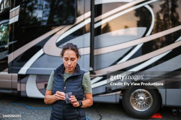 eurasian woman stands beside rv eating blueberries - pacific northwest staat stockfoto's en -beelden