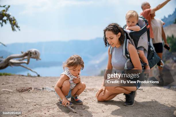 家族とハイキング中に土で遊ぶユーラシアの3歳の女の子 - 65 year old asian women ストックフォトと画像