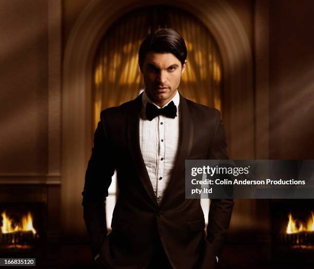 hispanic man in tuxedo standing in living room - smoking imagens e fotografias de stock