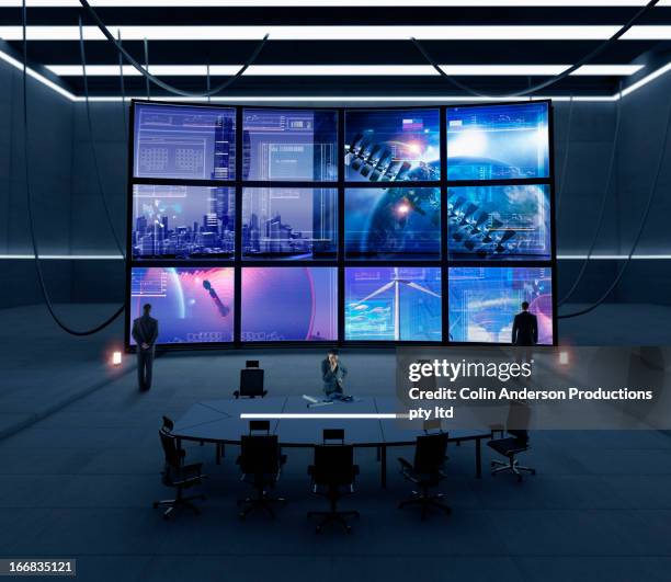 business people watching screens in conference room - control room stock pictures, royalty-free photos & images