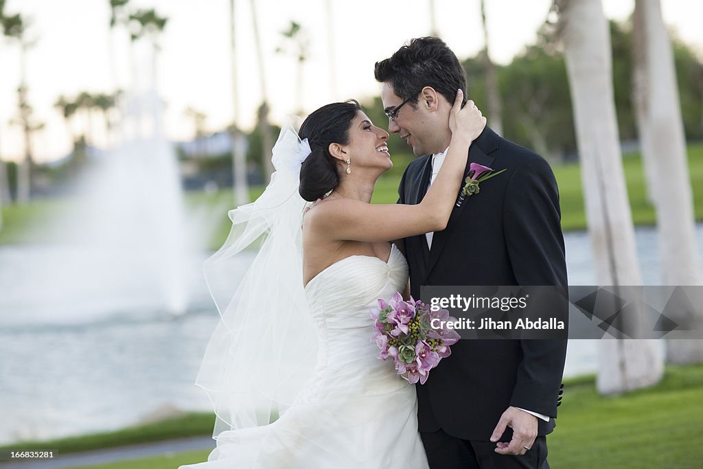 Newlywed couple smiling on golf course