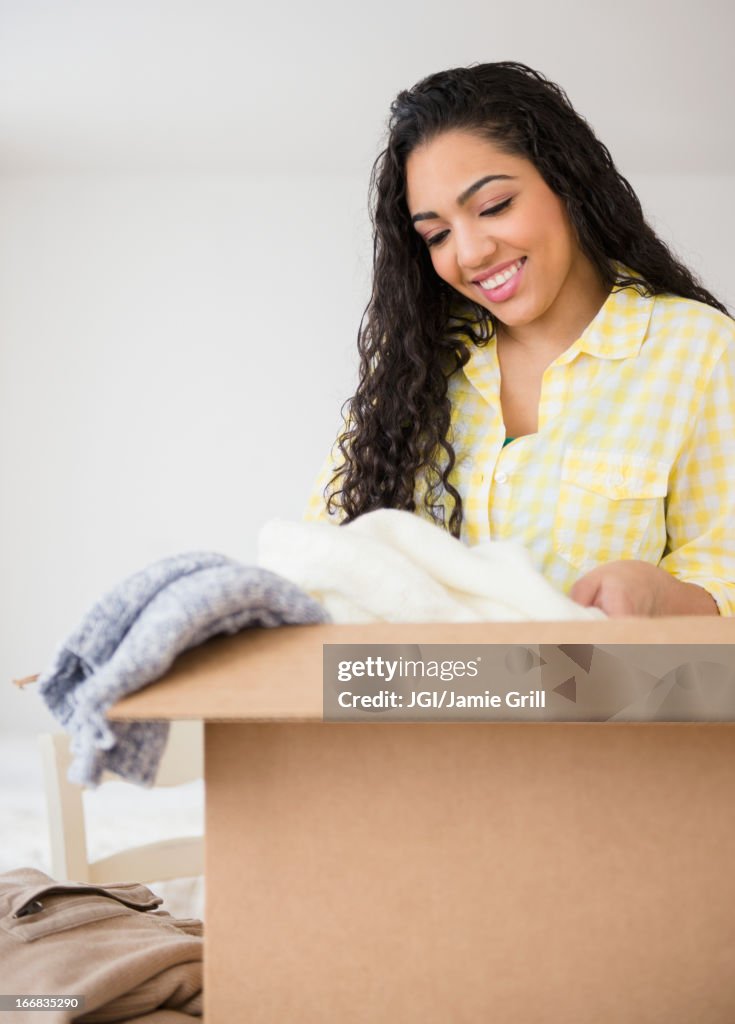 Hispanic woman unpacking cardboard box