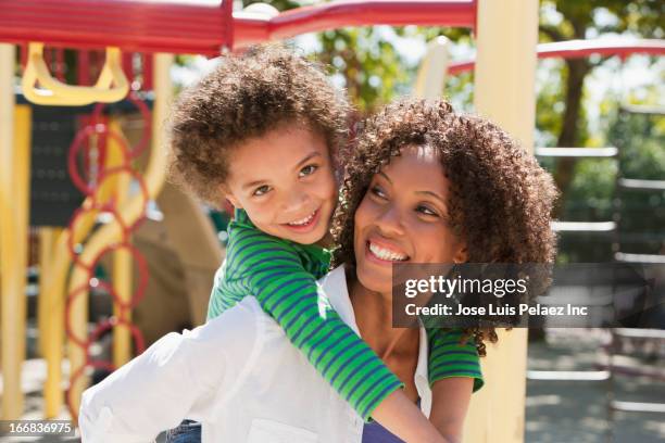 mother carrying son on playground - mother and son at playground stock-fotos und bilder