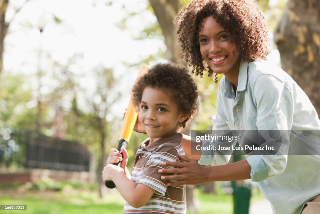 Mother and son playing baseball in park