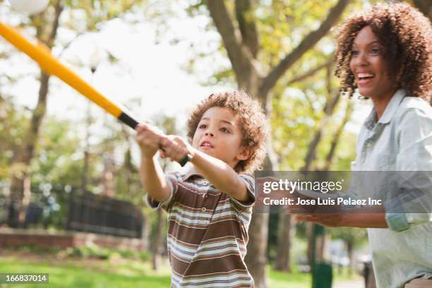 mother and son playing baseball in park - baseball mom stockfoto's en -beelden