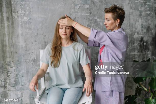 therapist holding hand on the patient's head during hypnotherapy. reiki therapy practice. bioenergy healing expert practices. alternative medicine, psychology, mental health concept. - hypnose stock-fotos und bilder