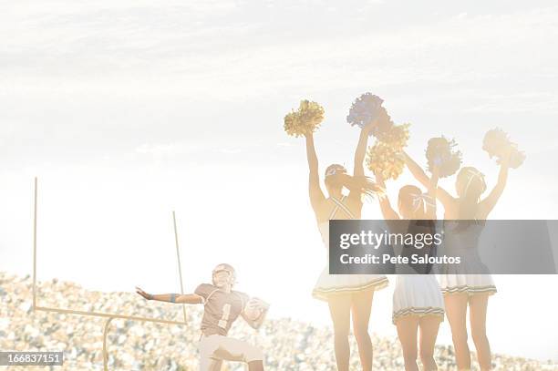 caucasian cheerleaders on sidelines at football game - football cheerleaders stock-fotos und bilder