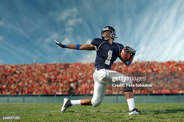 african american football player poised on field - profundo jugador de fútbol americano fotografías e imágenes de stock