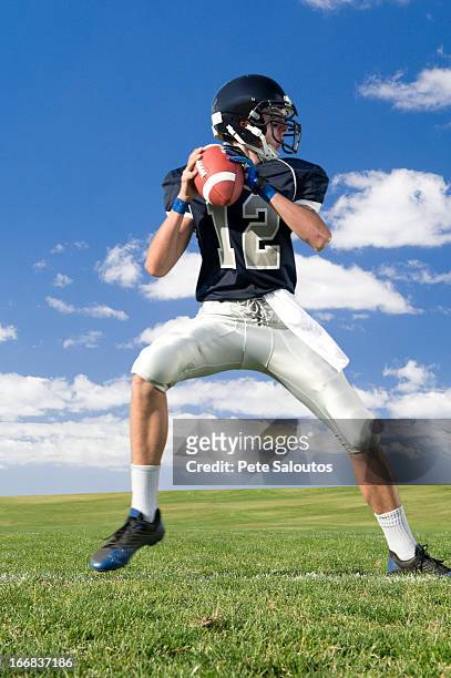 caucasian football player poised on field - quarterback stockfoto's en -beelden
