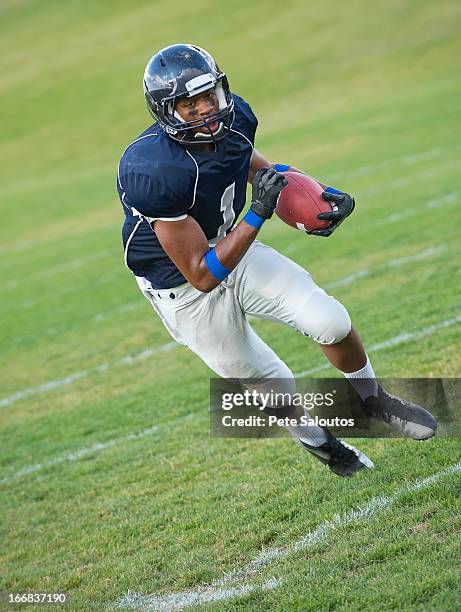 african american football player carrying ball - safety american football player stock pictures, royalty-free photos & images